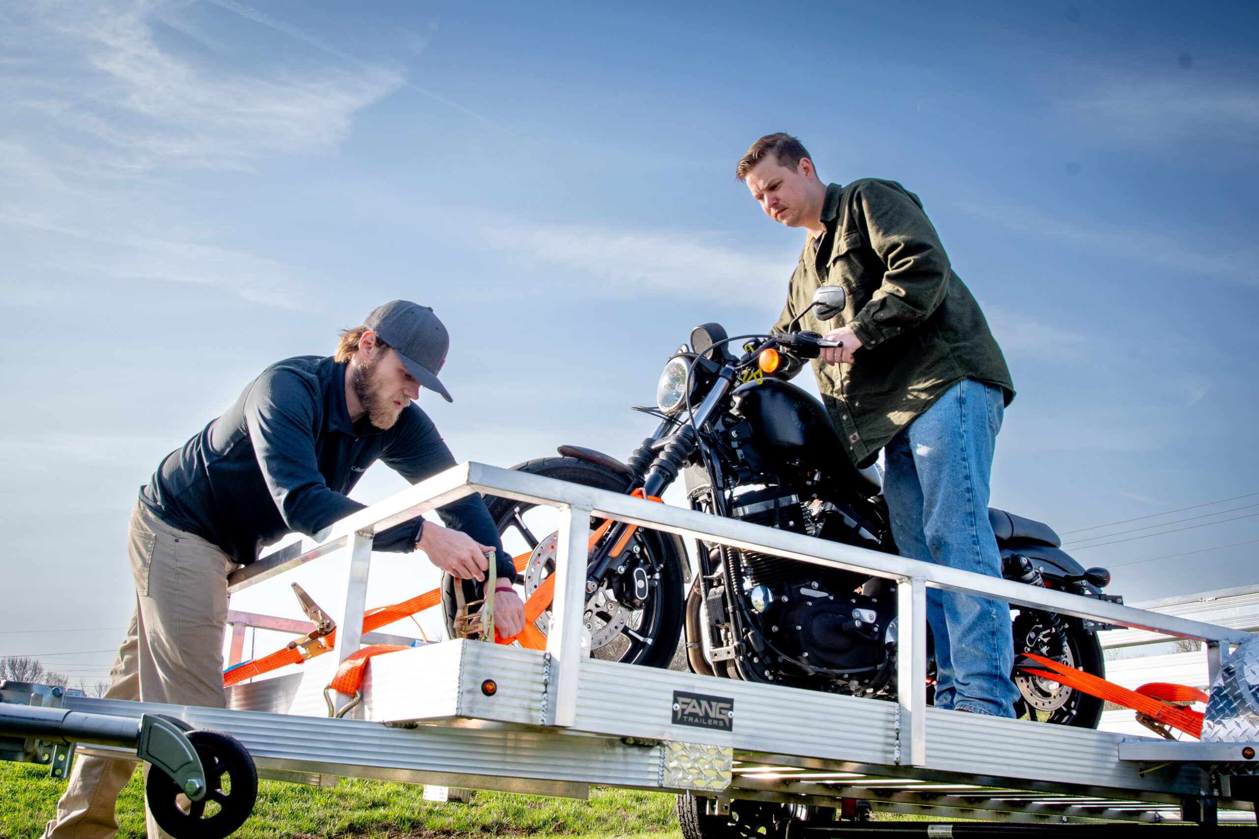 dudes loading up the motorcycle(