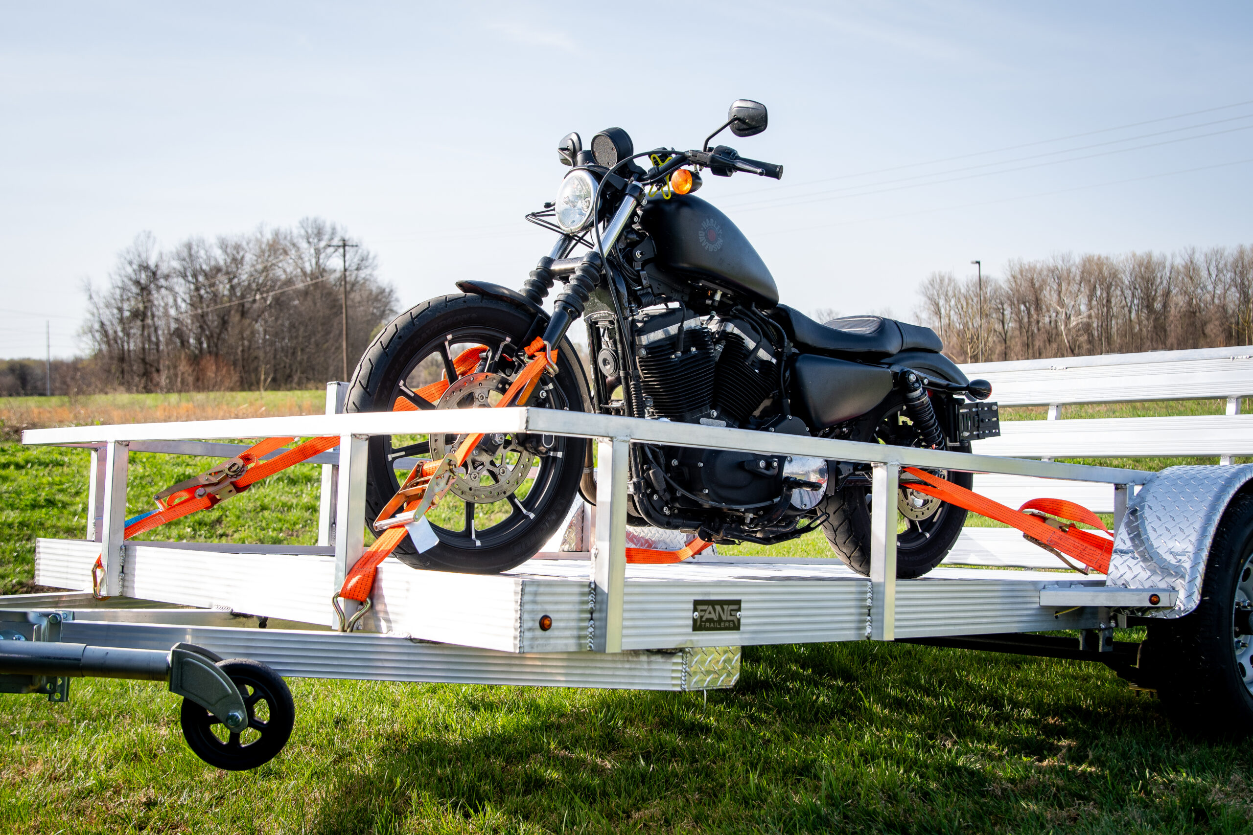 open plank aluminum trailer with motorcycle
