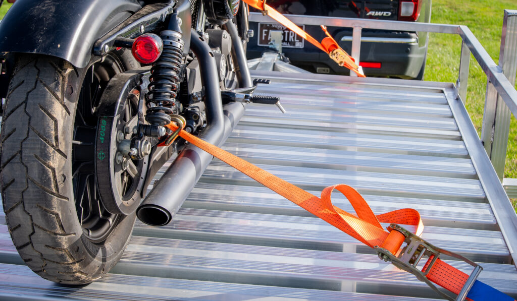 open plank aluminum trailer with motorcycle